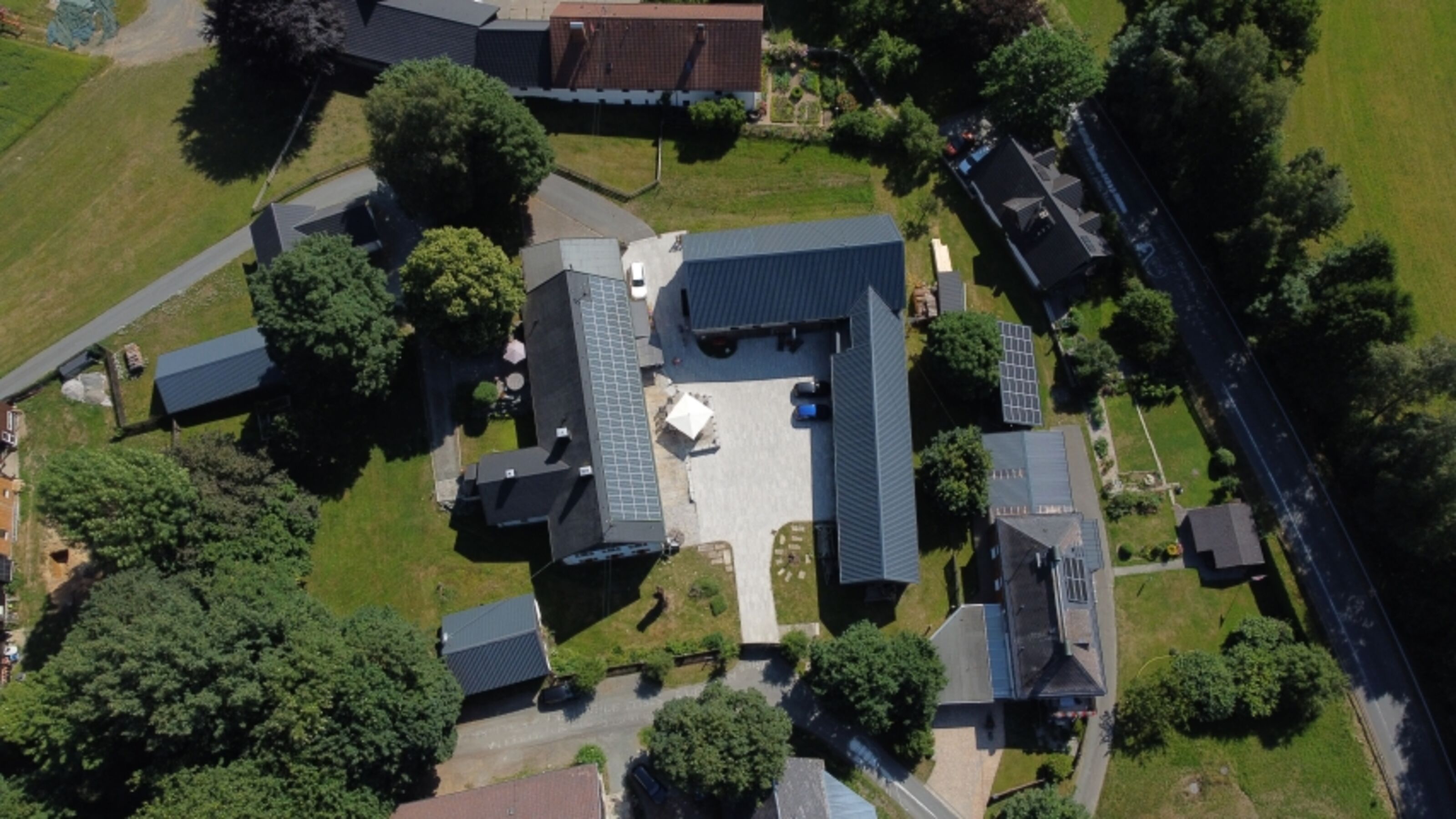 Unser Hof - auf der linken Seite Ihr eigener Bereich (Terrasse mit Sonnenschirm)