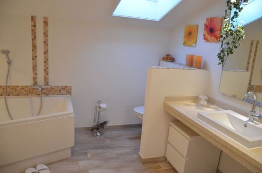 Großes Bad mit Wanne und Dusche, WC hinter Mauer