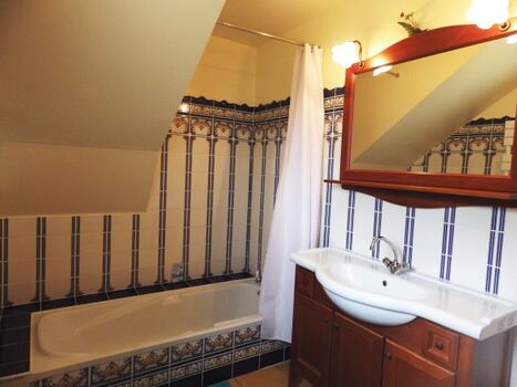 Das Badezimmer mit Badewanne und Duschvorrichtung