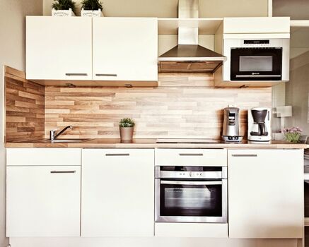 Vollständig ausgestattete Küche mit Backofen, Mikrowelle, Kühlschrank mit Gefrierfach