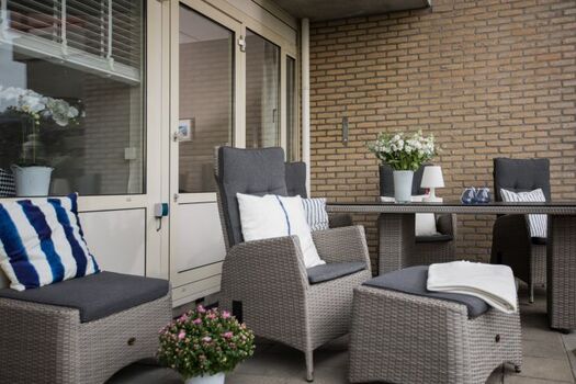 Die großzügige, teils überdachte Terrasse ist mit ganz gemütlichen Möbeln ausgestattet