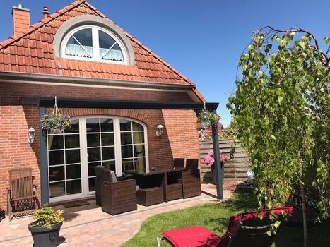 Blick in den eingezäunten Garten und auf die Terrasse