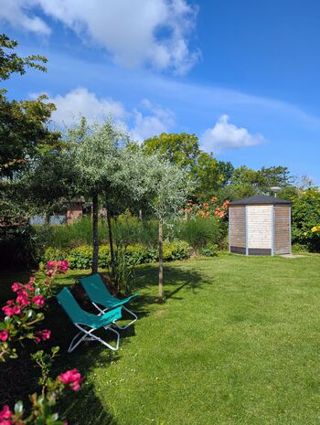Großer, sicher eingezäunter Garten mit schattigem Sitzplatz unter dem Baum.