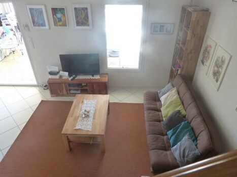 Wohnzimmer mit Blick durch den Wintergarten auf das Meer und den See