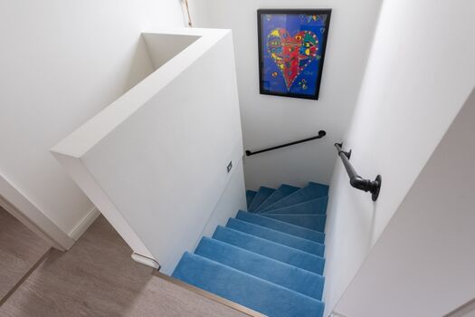 geschlossene Treppe mit Teppichbelag ins OG