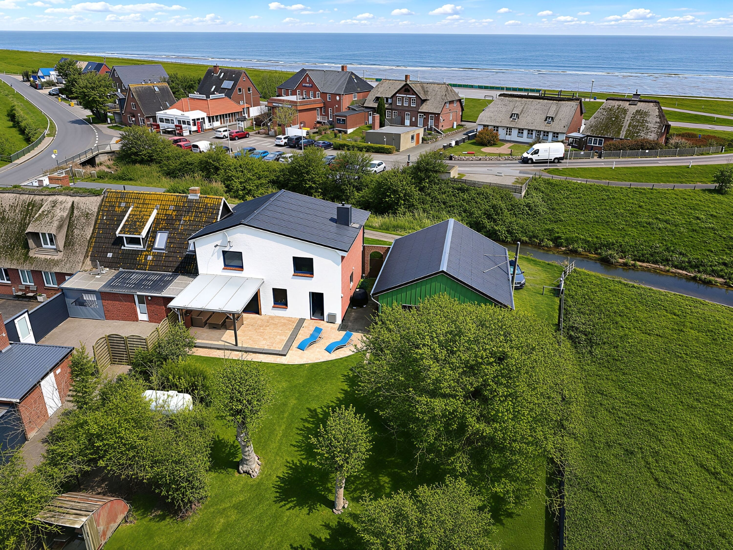 Luftansicht vom hinteren Garten auf Terrasse und Meer