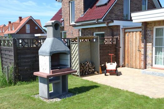 Grill im Garten om Ferienhaus Lüttet Strandhuus in Kalifornien an der Ostsee