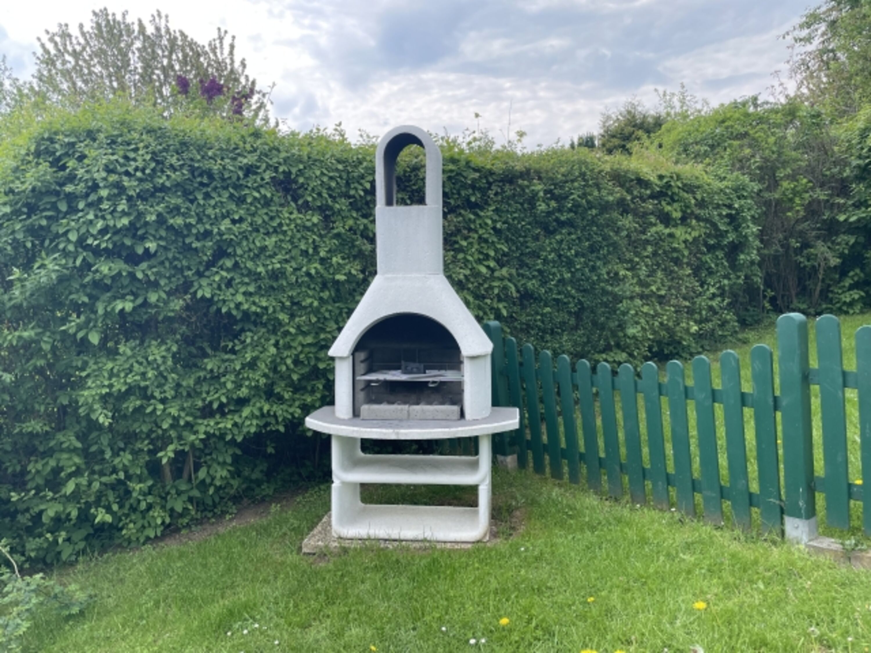 eingezäunter Garten mit Grillkamin