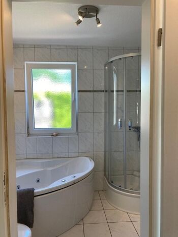 Badezimmer mit Whirlwanne, Dusche und Sauna