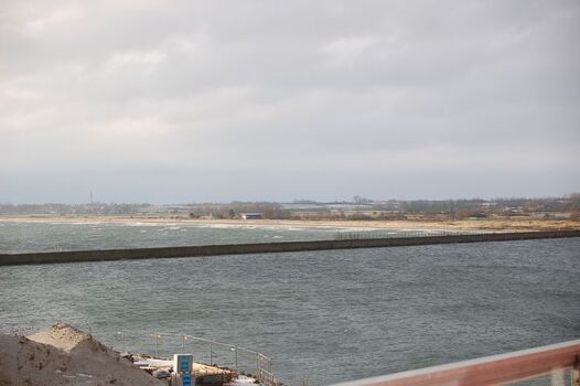 Blick auf die Hafeneinfahrt und den langen Sandstrand mit Hunde, Bade, Kitesurf und FFK Bereichen