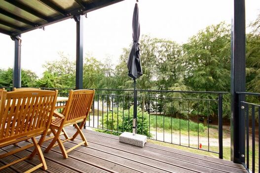 Balkon mit Gartenmöbeln und Schirm