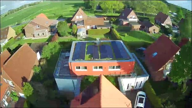 Blick von oben auf die Dachterrasse und PV-Anlage auf dem Hauptdach