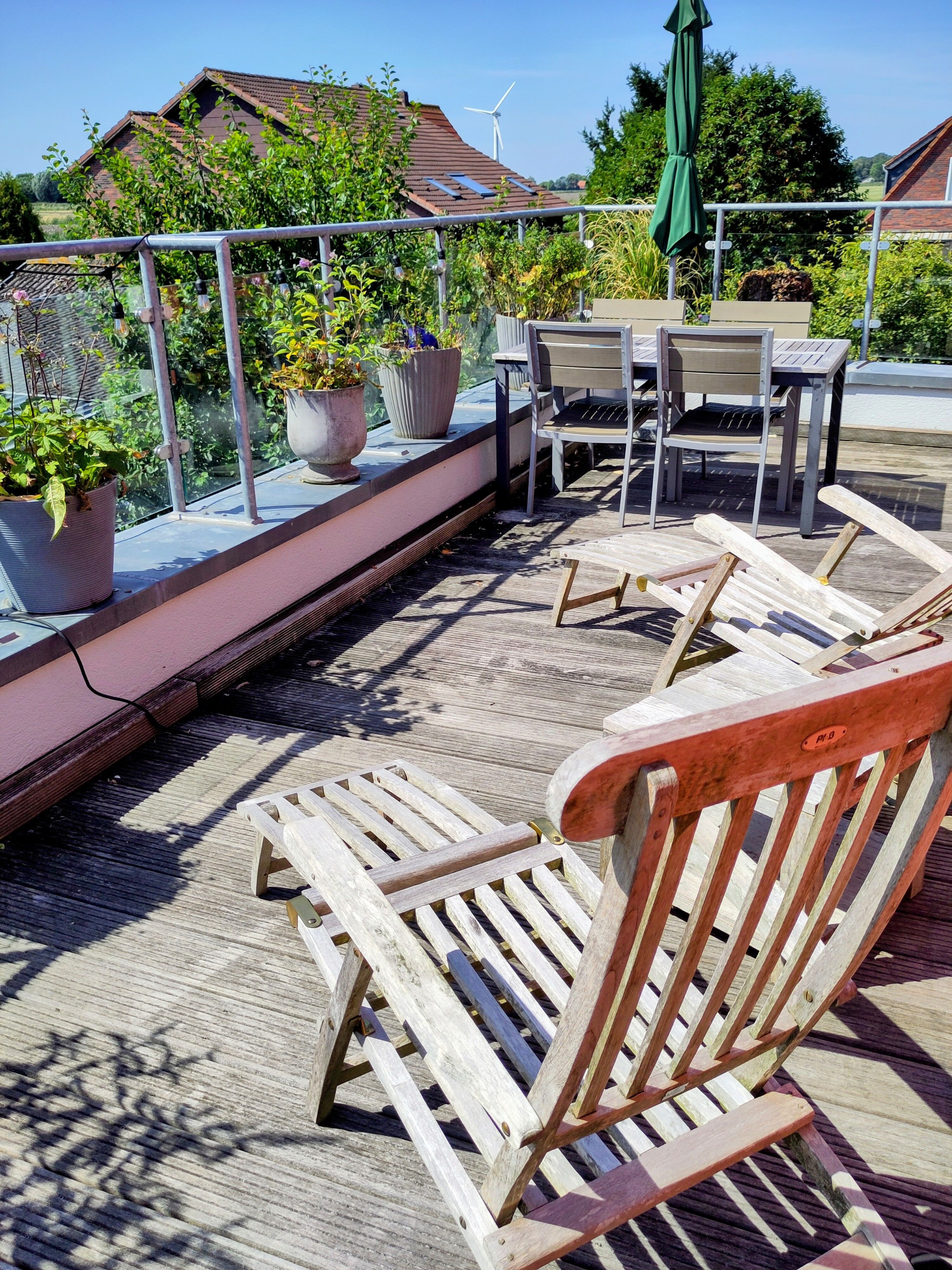 Esstisch und Liegestühle auf der Dachterrasse