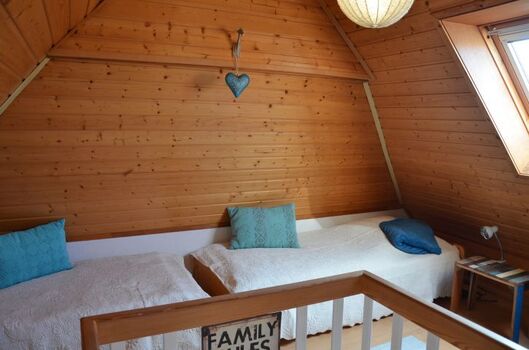 Offenes Galerieschlafzimmer mit zwei Einzelbetten für die Kids