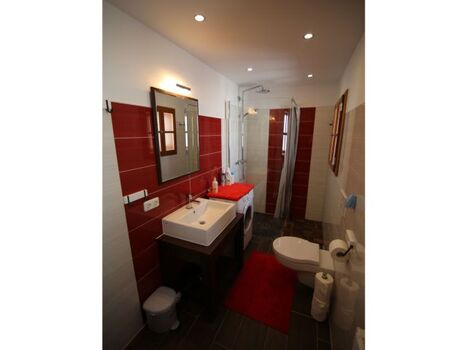 Modernes Badezimmer mit WC, Raindrop Shower und Waschmaschine.