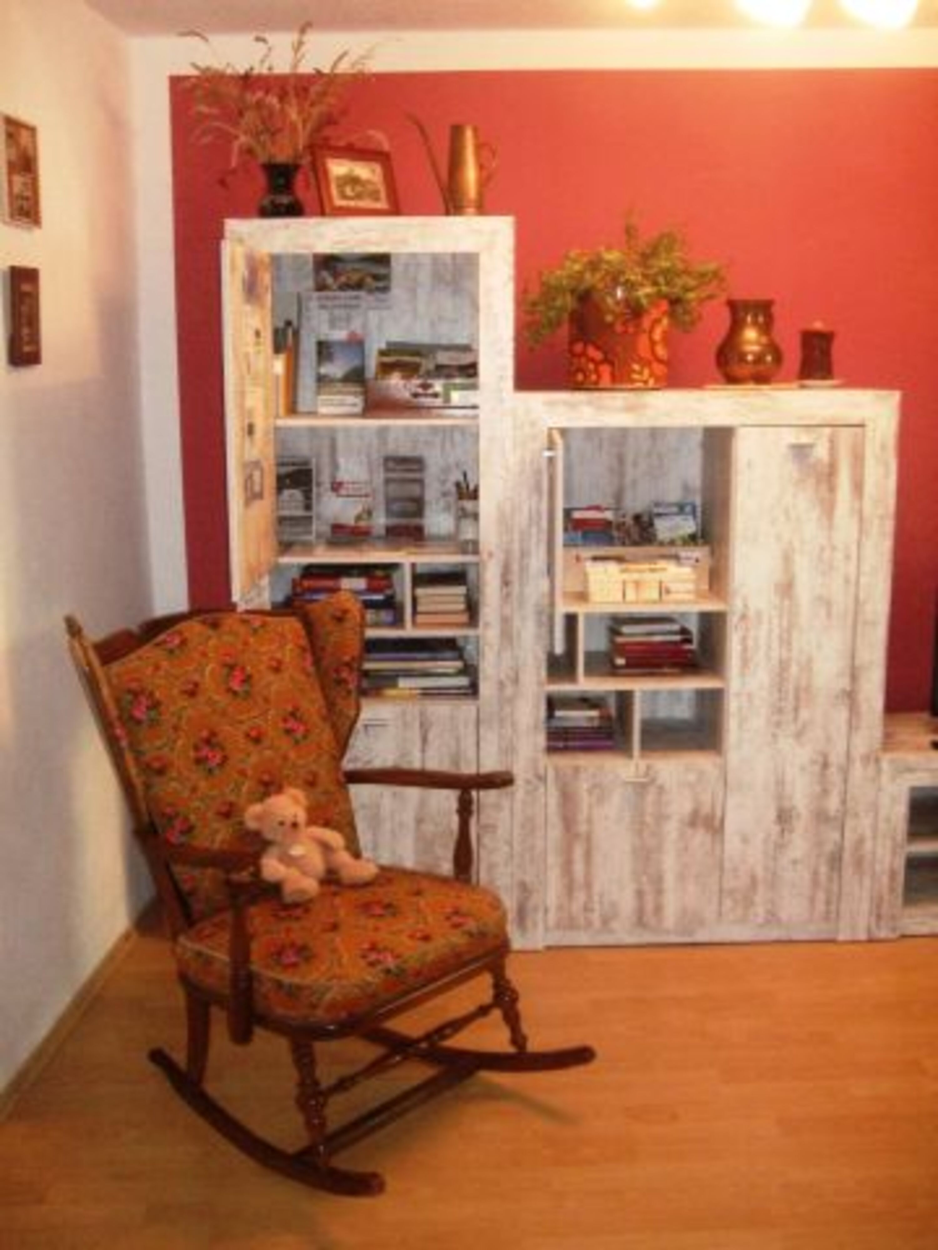 Wohnzimmer mit Schaukelstuhl, Büchern, Spielen, Regionsinfo
