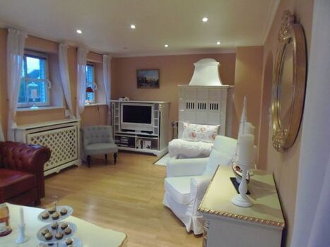 Antiker Kachelofen und weißer Flat-Screen-TV im Wohnzimmer