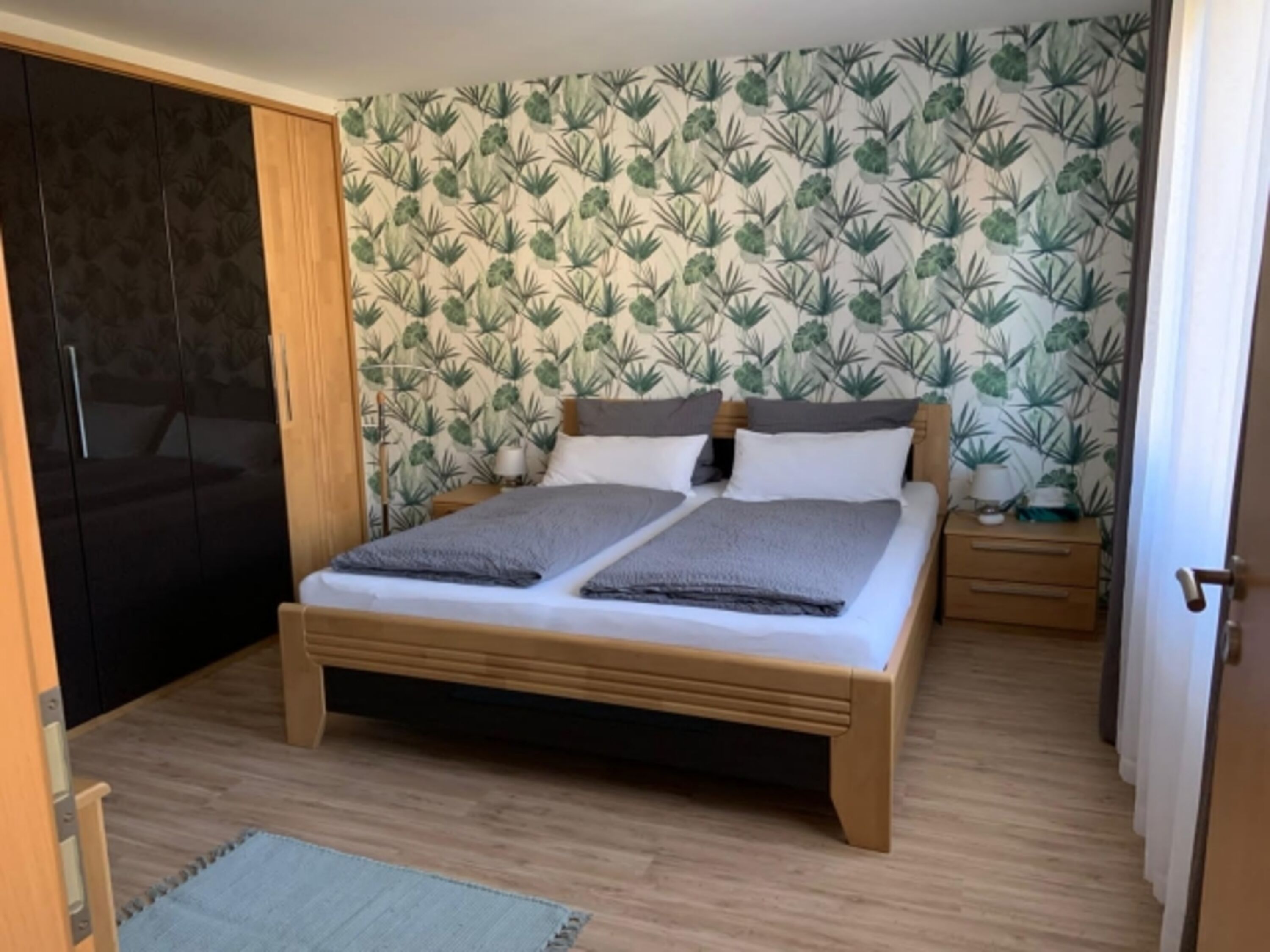 Bett in Komforthöhe und großer Kleiderschrank mit viel Stauraum.