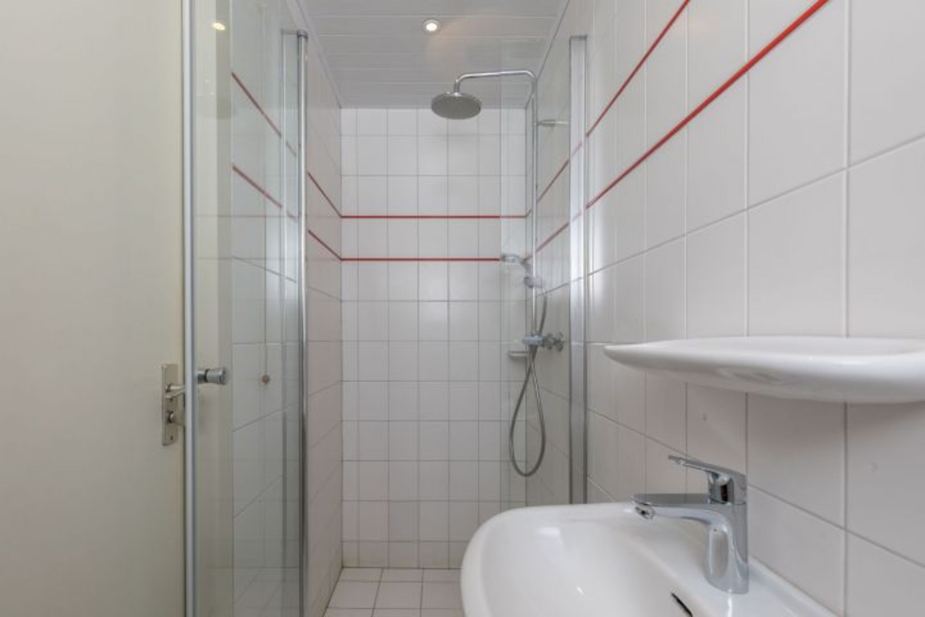 Badezimmer mit Dusche, Waschbecken und Toilette