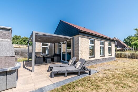 Ferienhaus mit eingezäuntem, sonnigem Garten, Lounge-Ecke und Grill.