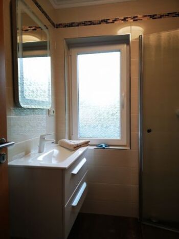 Bad mit beleuchtetem Spiegel