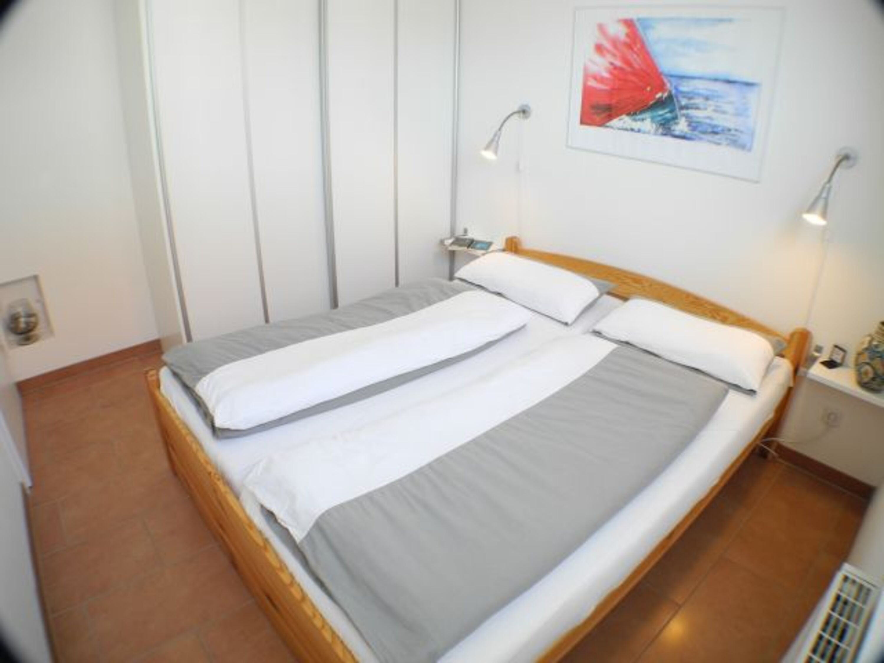 Schlafzimmer mit Doppelbett und großem Kleiderschrank.
