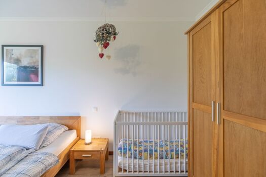 Haus am Deich - Hauptschlafzimmer mit Babybettchen 