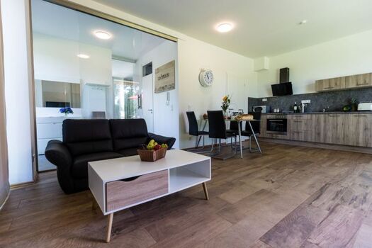 Wohnzimmer mit Küchenzeile und Esstisch für 4 Personen