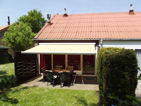 Rückseite des Ferienhauses mit Terrasse, Markise und Garten