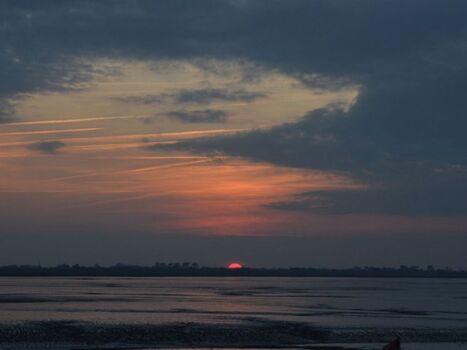 Der Feuerball versinkt hinter Wilhelmshaven