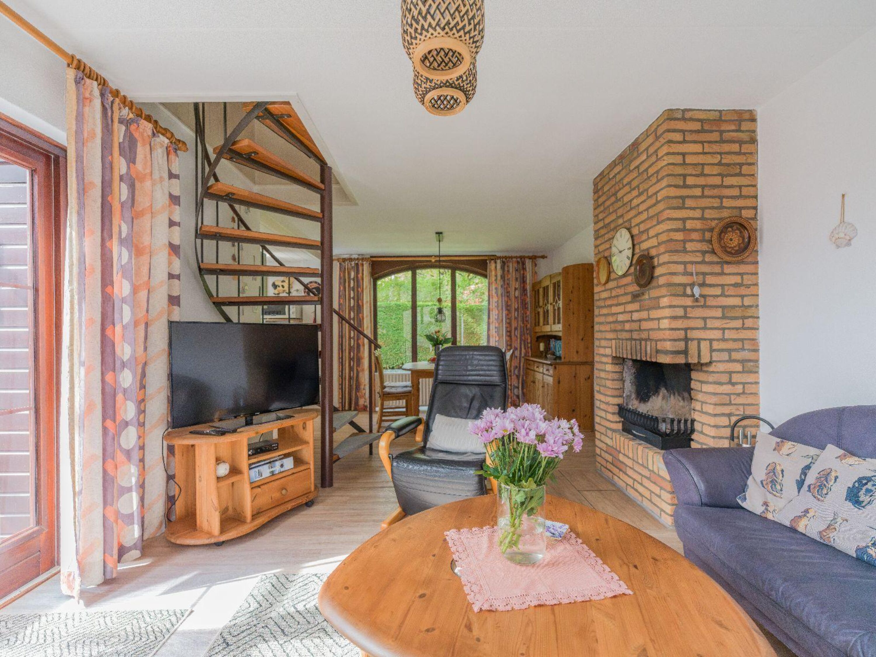 Wohnzimmer mit Kamin, Sitzecke und TV