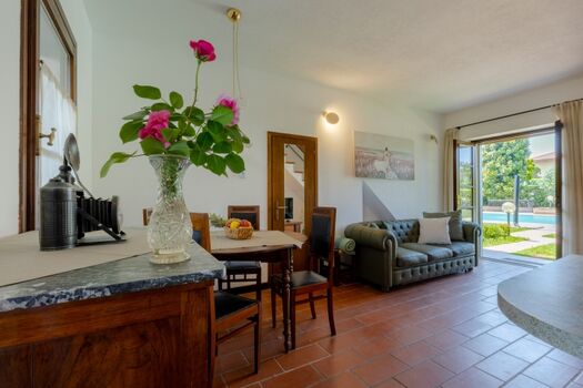 der Wohnraum mit Esstisch und Couch und Blick auf den Pool