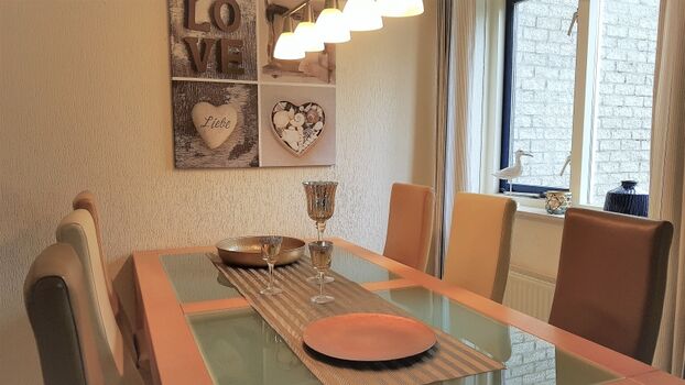 Esszimmer mit großem Tisch und 6 bequemen Lederstühlen