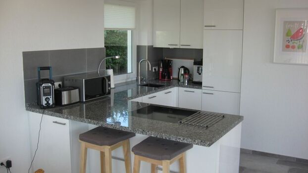 Offene Wohnküche mit Spülmaschine, Mikrowelle, Herd/Backofen, Kühlschrank, Tiefkühlschrank, Kaffeemaschine, Wasserkocher und alles was man noch so braucht. Eine Waschmaschine und einen Trockner finden Sie ausserhalb des Hauses im Nebeng