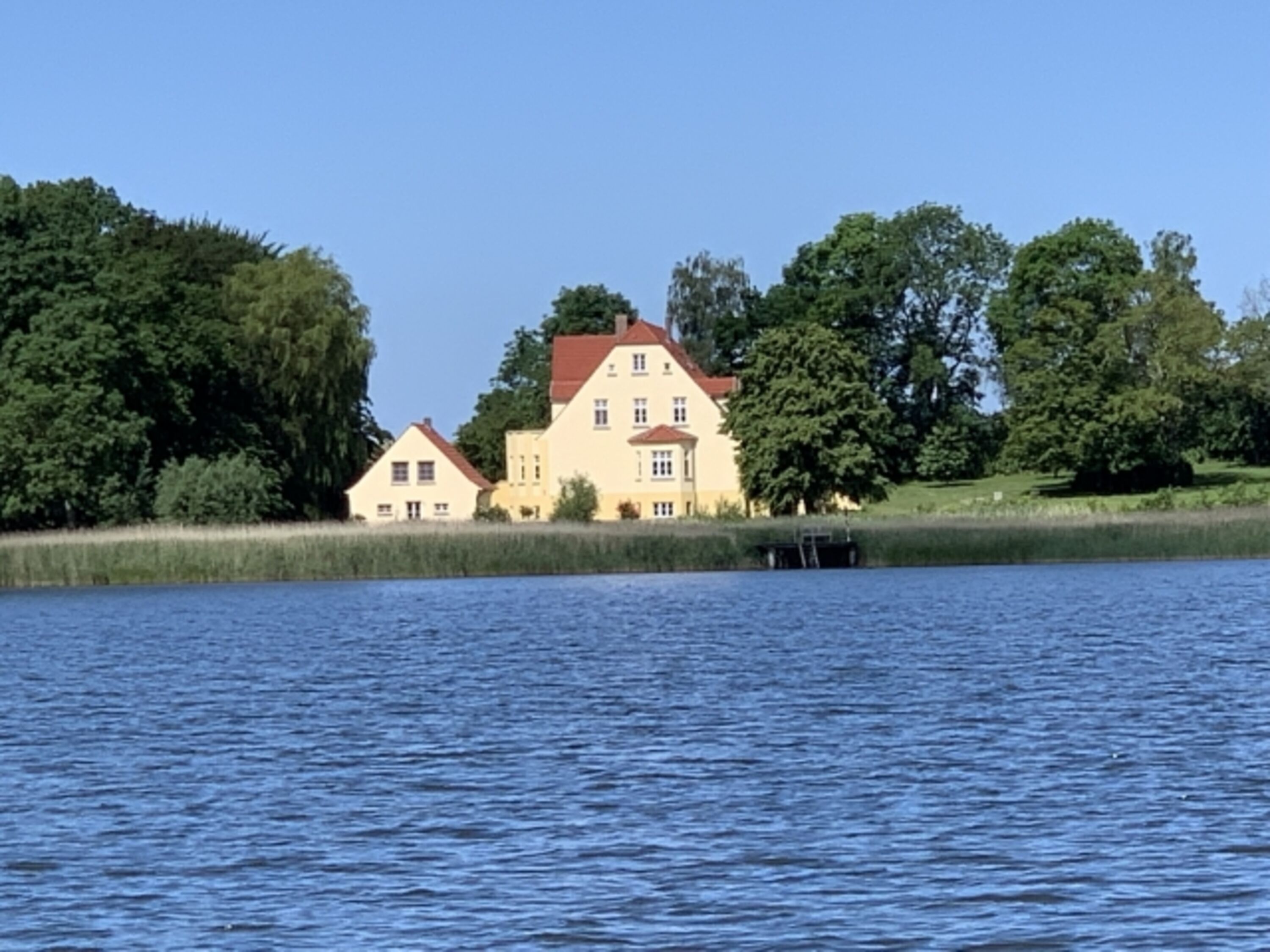Remise und Gutshaus vom Wasser gesehen