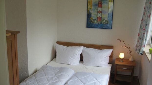 Hier sehen Sie das kleine Schlafzimmer mit dem 140er Bett, welches auch mit einem TV ausgestattet ist. Das Haus hat insgesamt 3 Schlafzimmer. 2 x mit 180er Doppelbetten im Souterrain und 1 x in der Paterre mit einem 140er Bett. Es ist also Platz für maxim