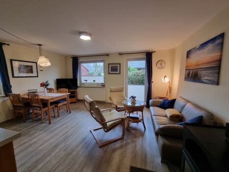 Wohnzimmer mit Kamin, gemütlicher Sitzecke und Essecke