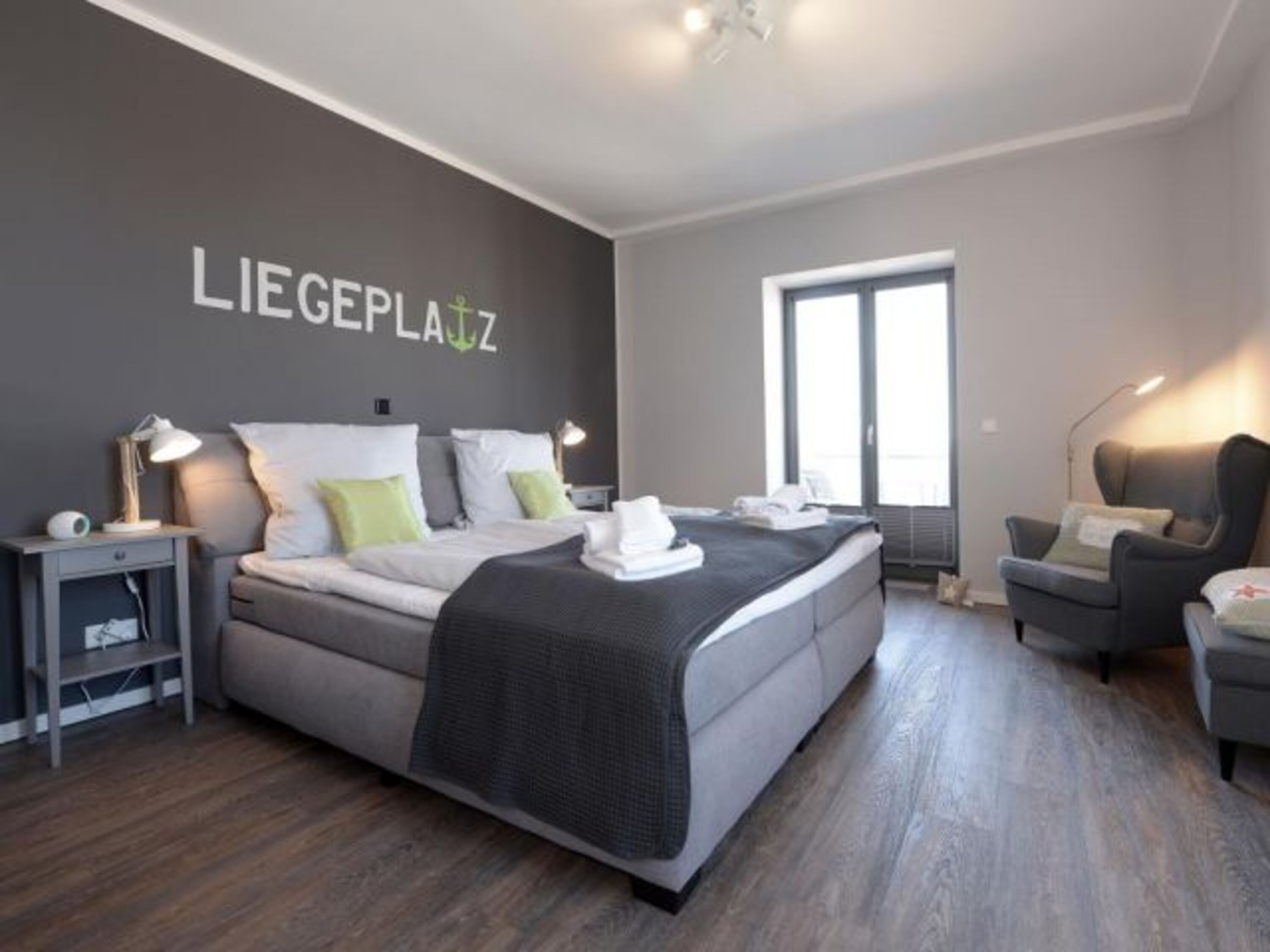 Schlafzimmer mit Boxspringbett 180 x 200 cm und Zugang zum Balkon.
