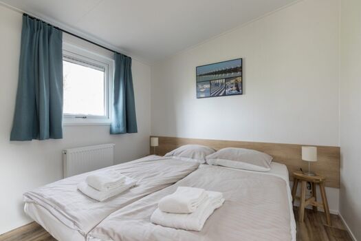 Erstes Schlafzimmer mit komfortablem Doppelbett