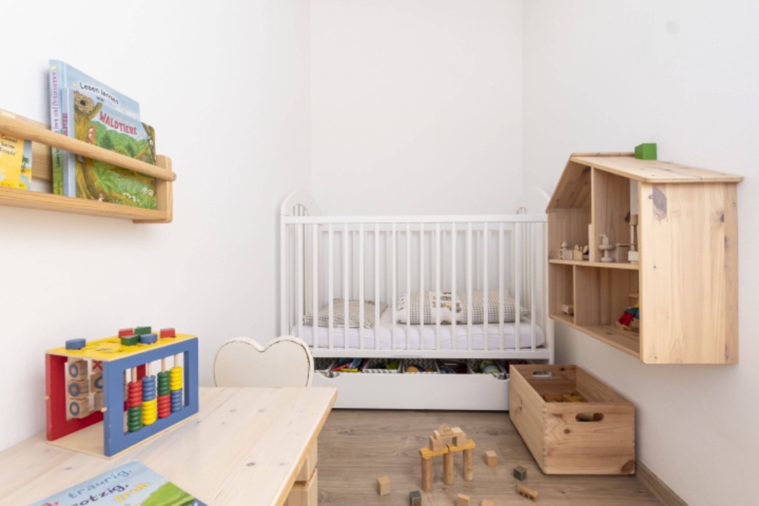 Kinderecke im Familienschlafzimmer mit Einschlaflicht, Sitzgruppe und Bettchen