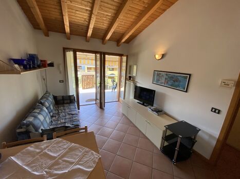 Das Wohnzimmer mit Schlafsofa, Esstisch und Kochnische