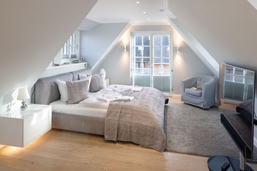 Schlafzimmer eins mit Freistehender Badewanne und Bad en Suite