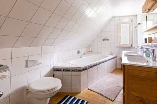 Badezimmer mit Wannenbad und Doppel-Waschbecken im OG