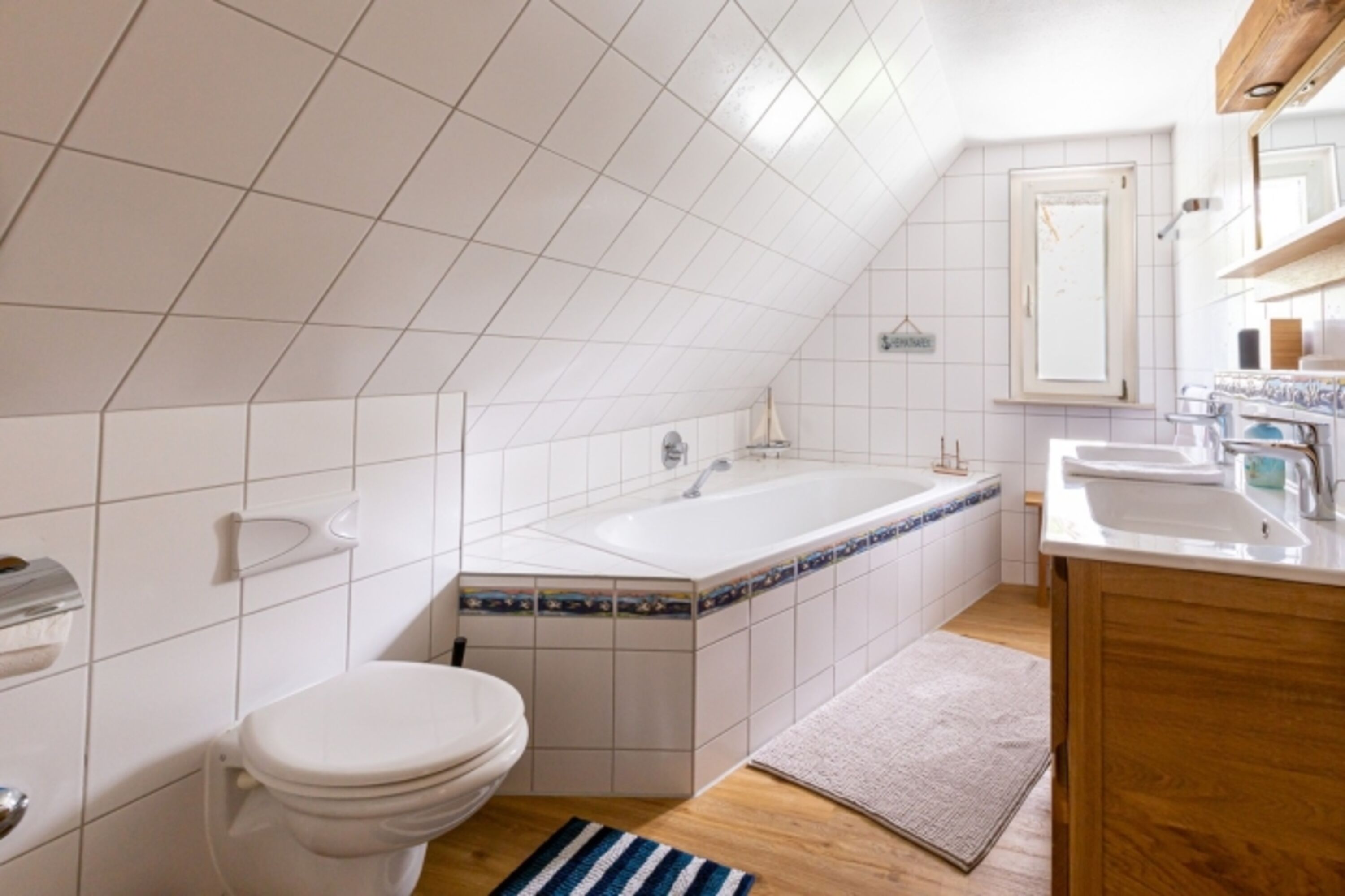 Badezimmer mit Wannenbad und Doppel-Waschbecken im OG