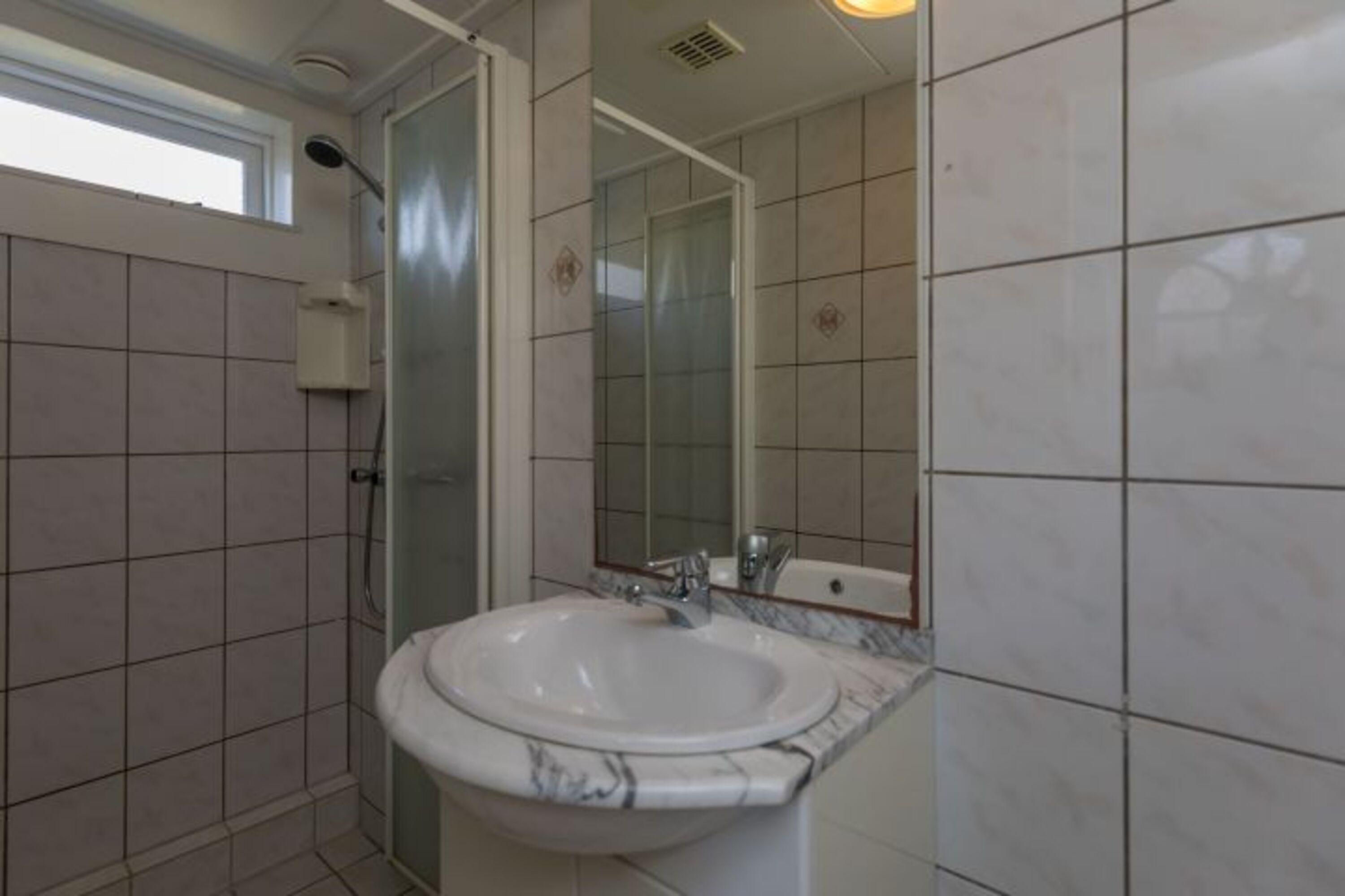 Badezimmer mit Dusche, Waschbecken und Toilette