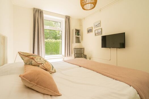 Schlafzimmer 1 mit 2 Boxspringbetten, Fernseher und Kleiderschrank