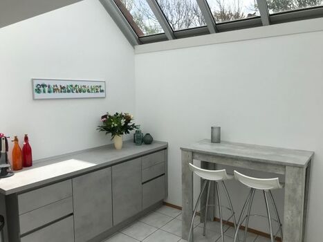 Wintergarten mit Hochtisch und Gartenblick