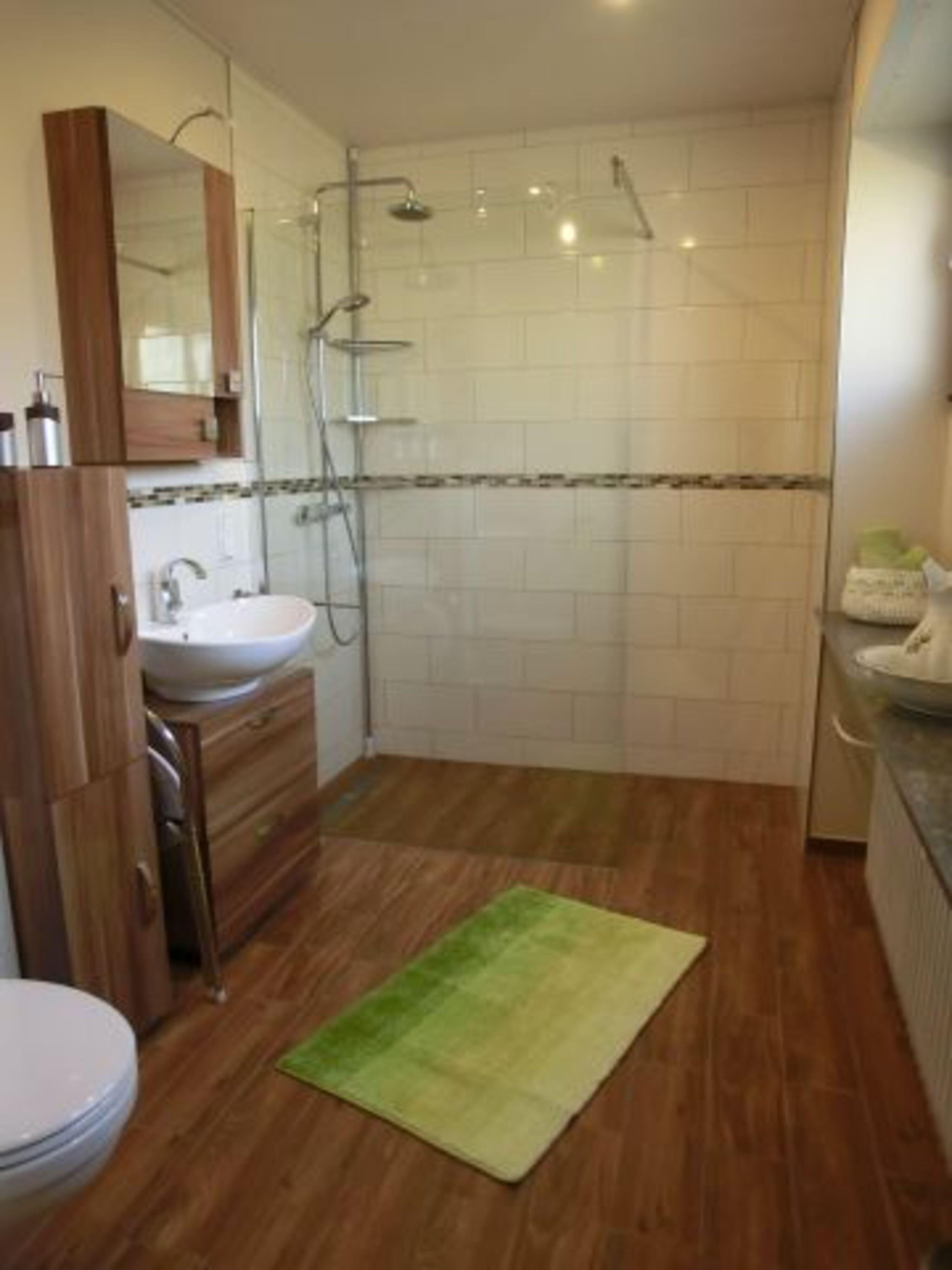Bad mit großer ebenerdiger Dusche und Toilette