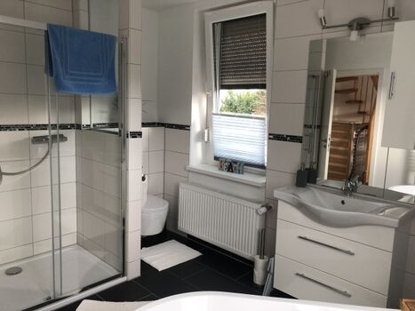 Bad mit Badewanne, Dusche, WC und Waschplatz im 1. OG