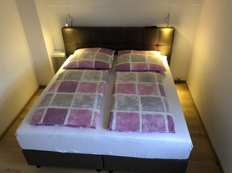 Schlafzimmer im OG mit Boxspringbett und Leselampen